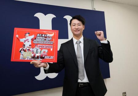 　契約を更改し、ボードを持ってポーズを決める島内（撮影・市尻達拡）