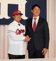 　新井監督と握手するドラフト４位の工藤泰己（撮影・市尻達拡）