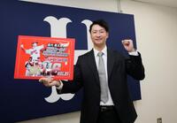 　契約を更改し、ボードを持ってポーズを決める島内（撮影・市尻達拡）