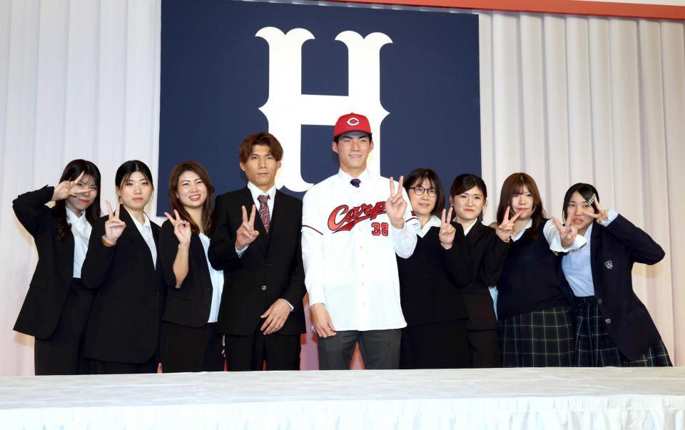 　大家族と記念撮影に応じる、ドラフト５位の赤木（撮影・市尻達拡）