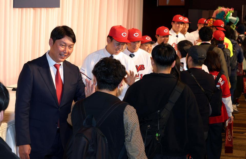 　入団会見に参加したファンとタッチを交わす新井監督と新人選手たち（撮影・市尻達拡）