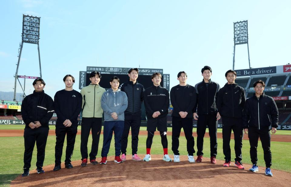 　初めて訪れたマツダスタジアムで、小園（中央）と記念撮影する広島の新人たち（撮影・市尻達拡）
