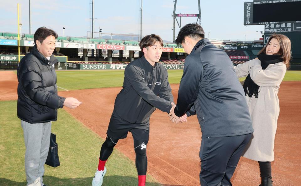 　ドラフト１位の平川蓮と握手をする小園。左は、父で、北海高校野球部監督の敦さん（撮影・市尻達拡）