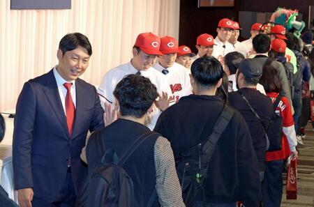 　１５日の新入団会見で参加したファンとタッチを交わす新井監督と新人選手たち