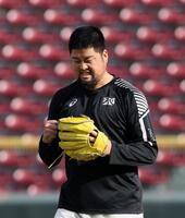 　キャッチボール相手の河野に、力まないことの重要性を、実演して説く中崎（撮影・市尻達拡）