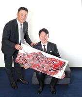 　鯉柄の手拭いを手に笑顔を見せる金本氏（左）と新井監督