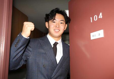 　部屋の中で拳を握る平川