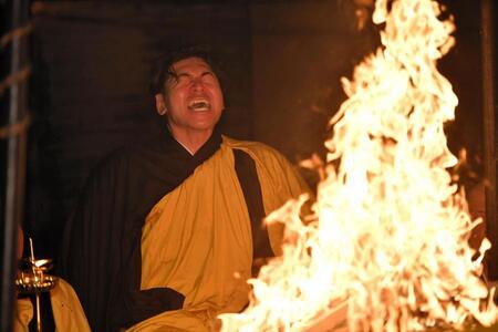 燃えさかる火柱の前で経を唱え続ける会沢（撮影・畠山賢大）