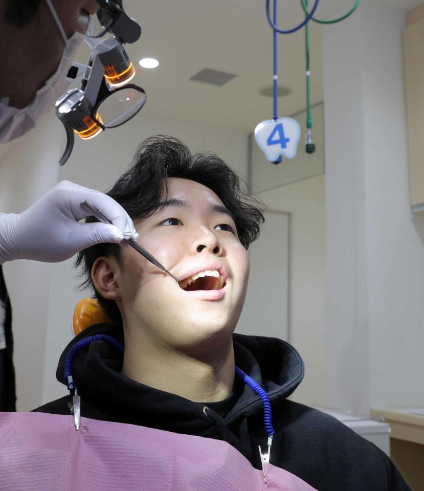 　歯のチェックをする平川