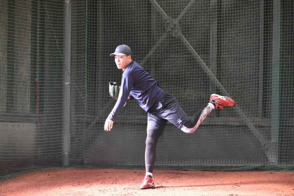 ブルペンで投球練習を行う滝田