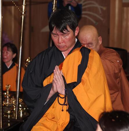 護摩行を終え、手を合わせる新井監督。奥は池口恵観大僧正（撮影・中田匡峻）