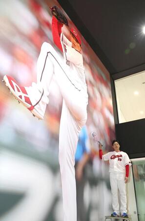 巨大壁画にサインを入れる栗林（撮影・北村雅宏）