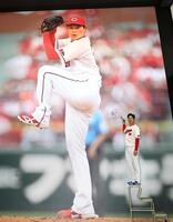 巨大壁画にサインを入れる栗林（撮影・北村雅宏）