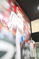 巨大壁画にサインを入れる栗林（撮影・北村雅宏）