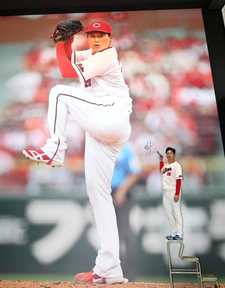 巨大壁画にサインを入れる栗林（撮影・北村雅宏）