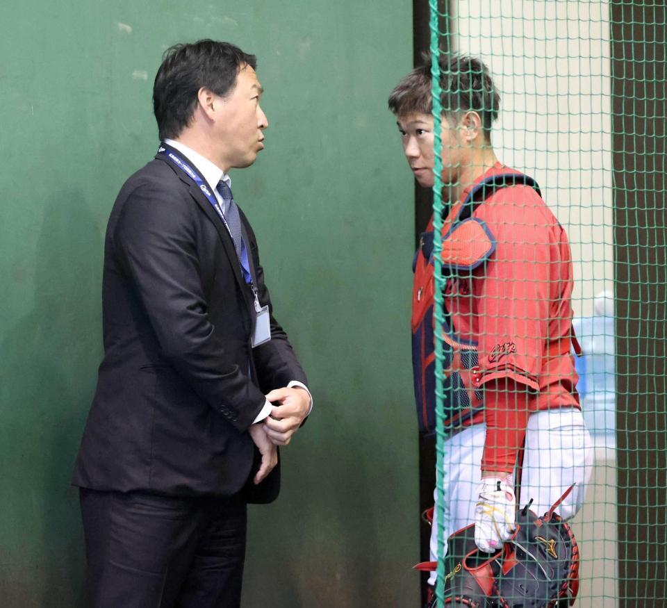 ブルペンで長野久義氏（左）と話し込む坂倉