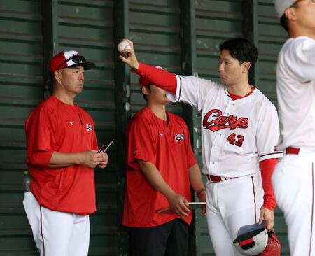 　ブルペンで石井コーチ（左）に変化球の握りを見せる島内（右）＝撮影・北村雅宏