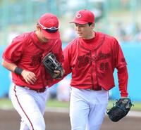 ２回、ピンチを無失点で切り抜けた栗林（右）は佐々木を迎える