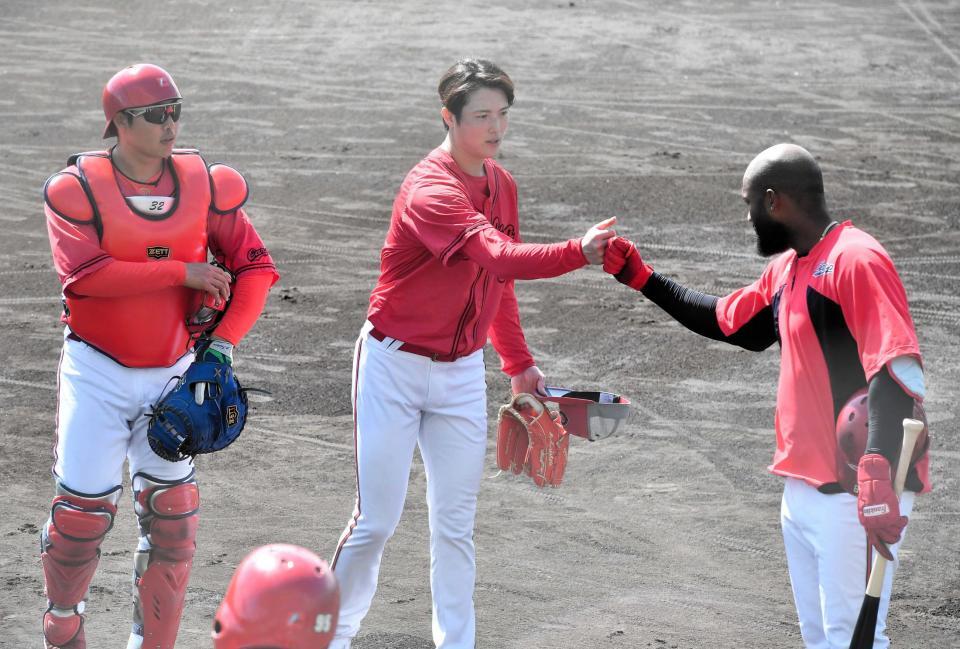 シート打撃を終えてファビアンとグータッチする森下（真ん中）＝撮影・畠山賢大