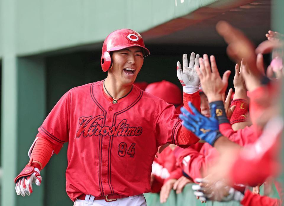 ９回、ソロを放ち、ナインとタッチを交わす佐藤啓（撮影・北村雅宏）