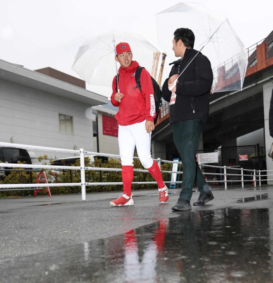 室内での練習を終え、傘を差してスタジアムに向かう平川（左）