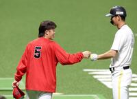 試合前、秋広とタッチを交わす小園（左）＝撮影・北村雅宏