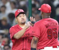 ６回、牧原大を一ゴロに打ち取り、モンテロとタッチを交わす中崎（左）＝撮影・北村雅宏