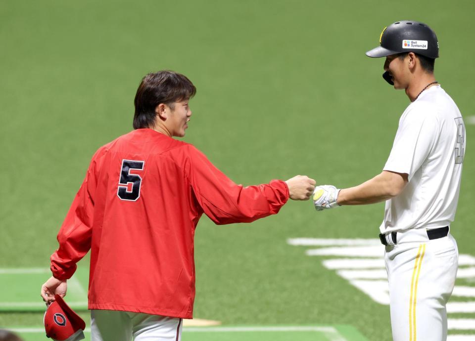 試合前、秋広とタッチを交わす小園（左）＝撮影・北村雅宏