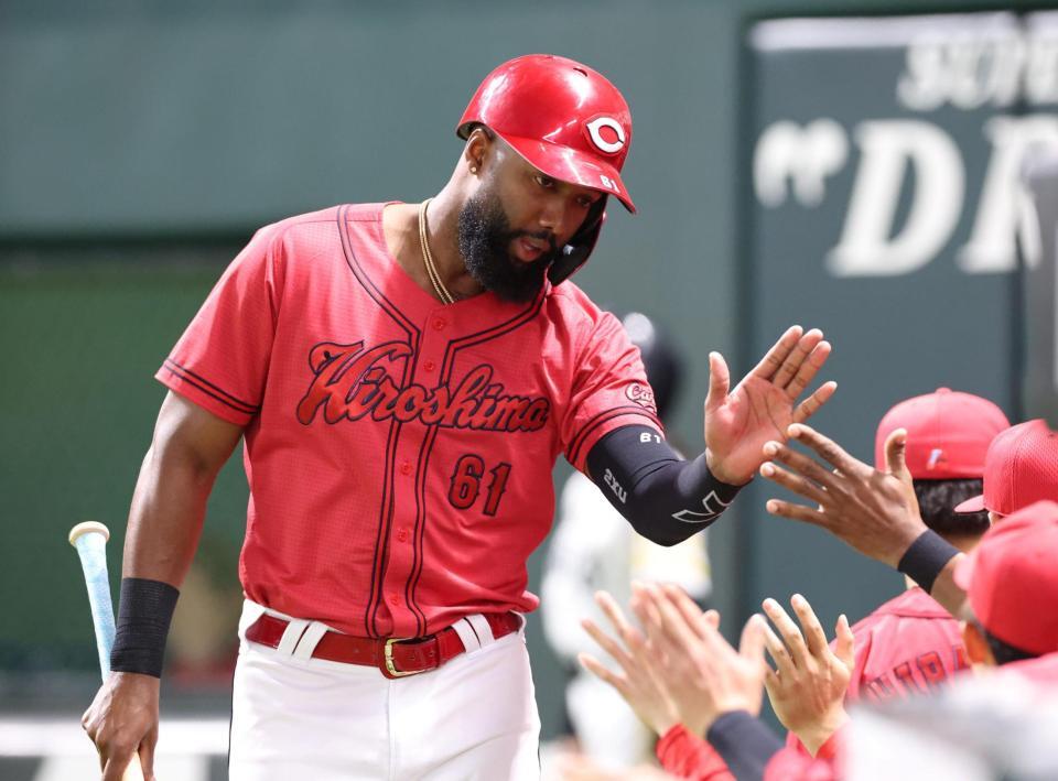 ２回、上沢の暴投で先制となる生還を果たし、ナインとタッチを交わすファビアン（撮影・北村雅宏）