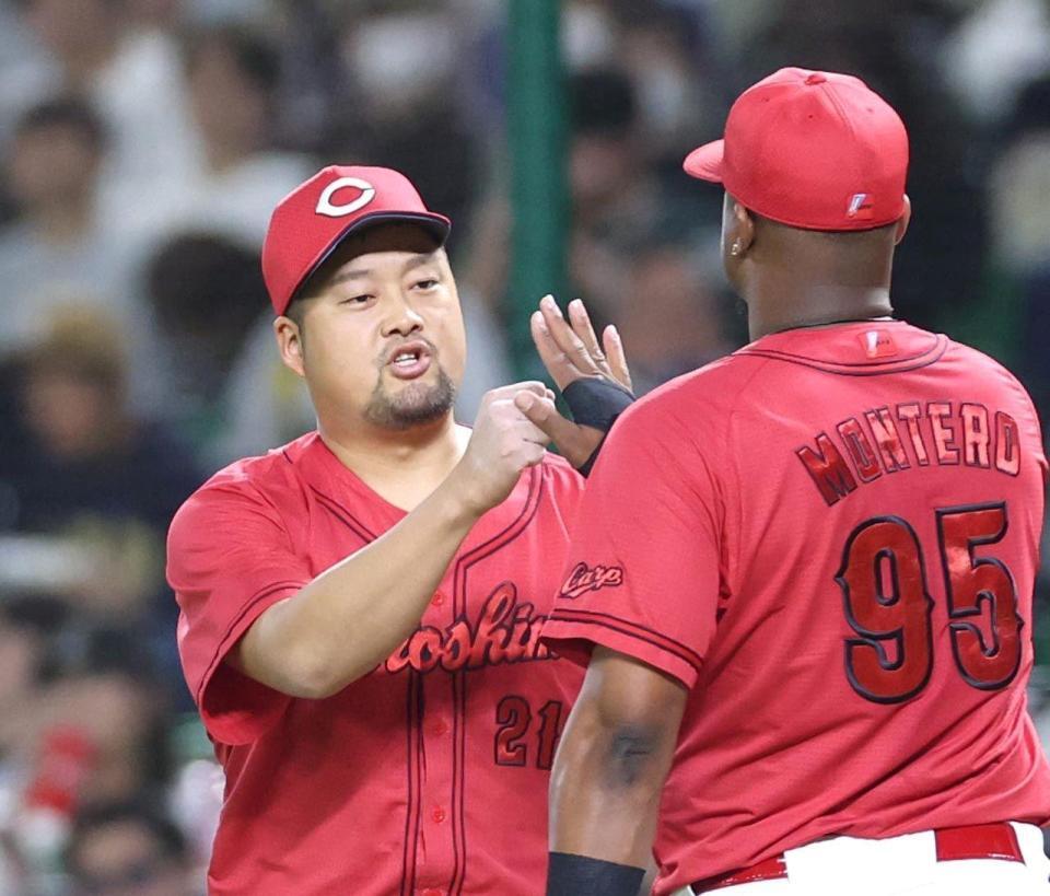 ６回、牧原大を一ゴロに打ち取り、モンテロとタッチを交わす中崎（左）＝撮影・北村雅宏