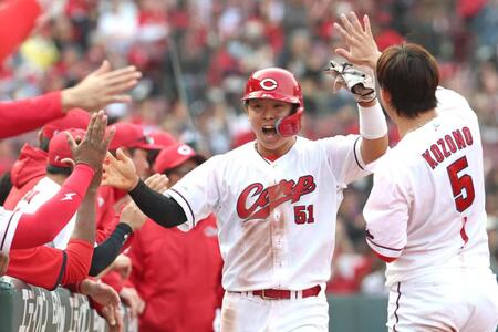 ８回、ファビアンの勝ち越し適時打で生還し、ナインとタッチを交わす平川（中央）＝撮影・北村雅宏