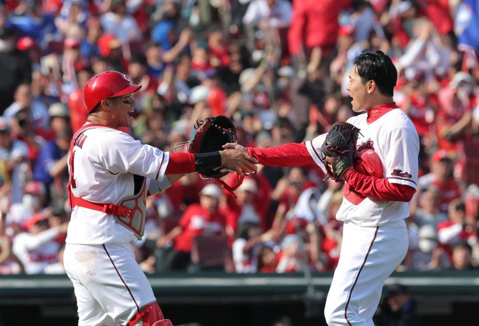 完封勝利を挙げ、坂倉と握手を交わす栗林（右）＝撮影・北村雅宏