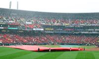 雨が強くなり試合が中断し、グラウンドにシートが敷かれる（撮影・山口登）