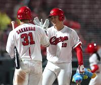 ８回、ソロを放ち、坂倉とタッチを交わす佐々木（右）＝撮影・北村雅宏