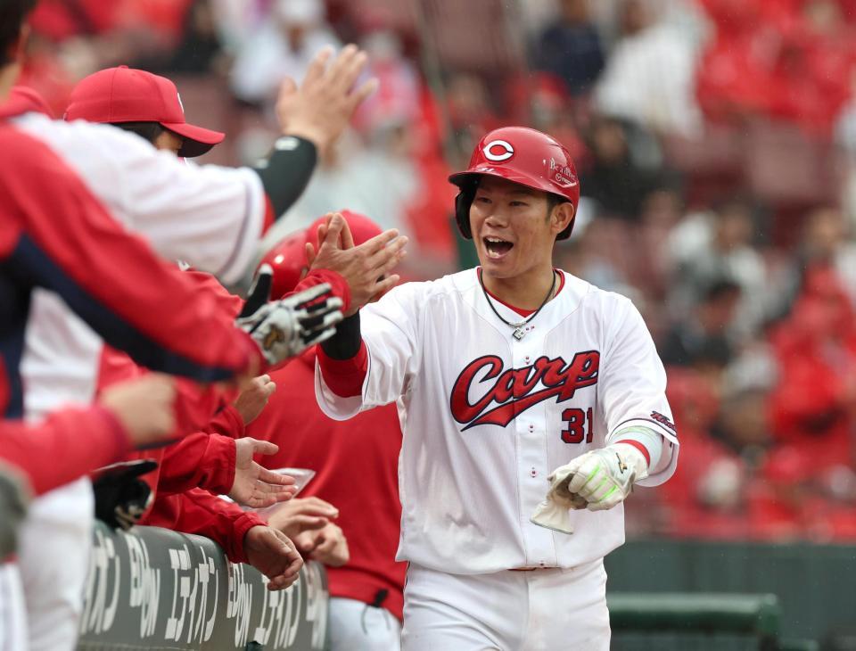 ４回、同点適時打を放った坂倉はベンチ前でタッチを交わす（撮影・北村雅宏）