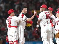 ９回、最後を締めた中崎（左から２人目）はナインとタッチを交わす（撮影・北村雅宏）