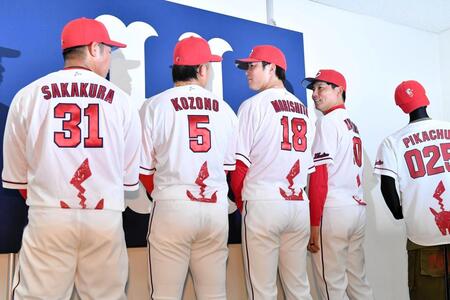 ピカチュウの尻尾がデザインされたイベントユニホームの撮影中に見つめ合う小園（左から２人目）と森下