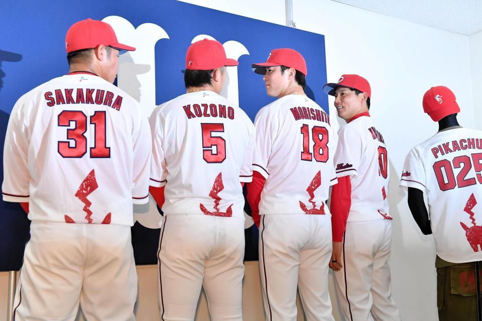 ピカチュウの尻尾がデザインされたイベントユニホームの撮影中に見つめ合う小園（左から２人目）と森下