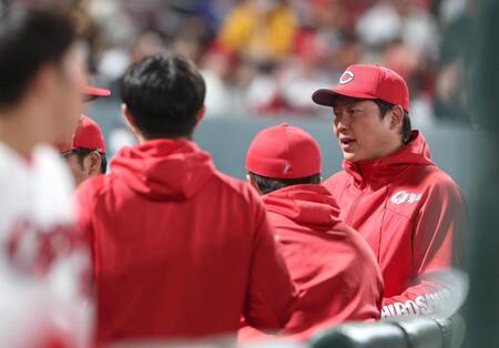 ５回の攻撃前、首脳陣と話し込む新井監督（右）