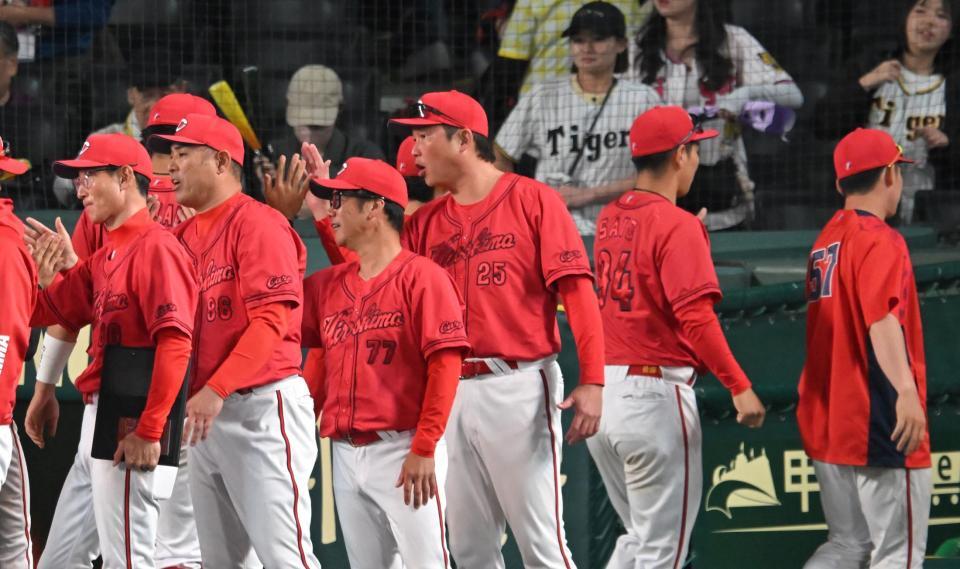 執念のドロー。ナインをハイタッチで迎える新井監督（撮影・飯室逸平）