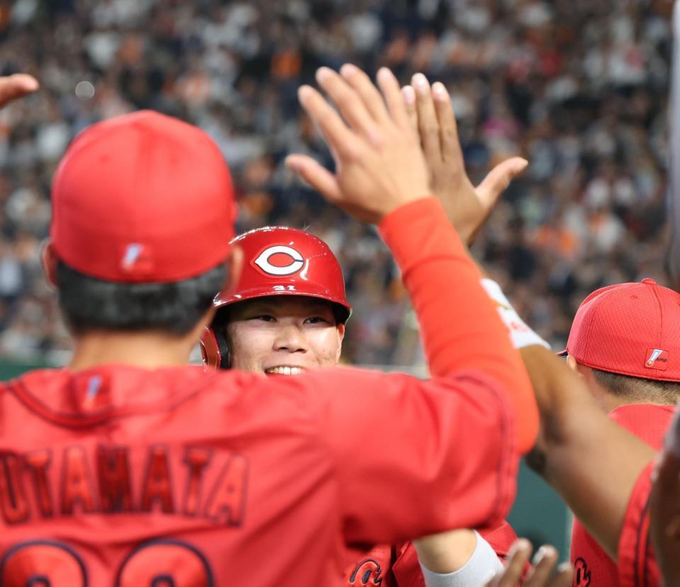 ５回、３ランを放ちベンチ前でナインに出迎えられる坂倉（撮影・佐々木彰尚）