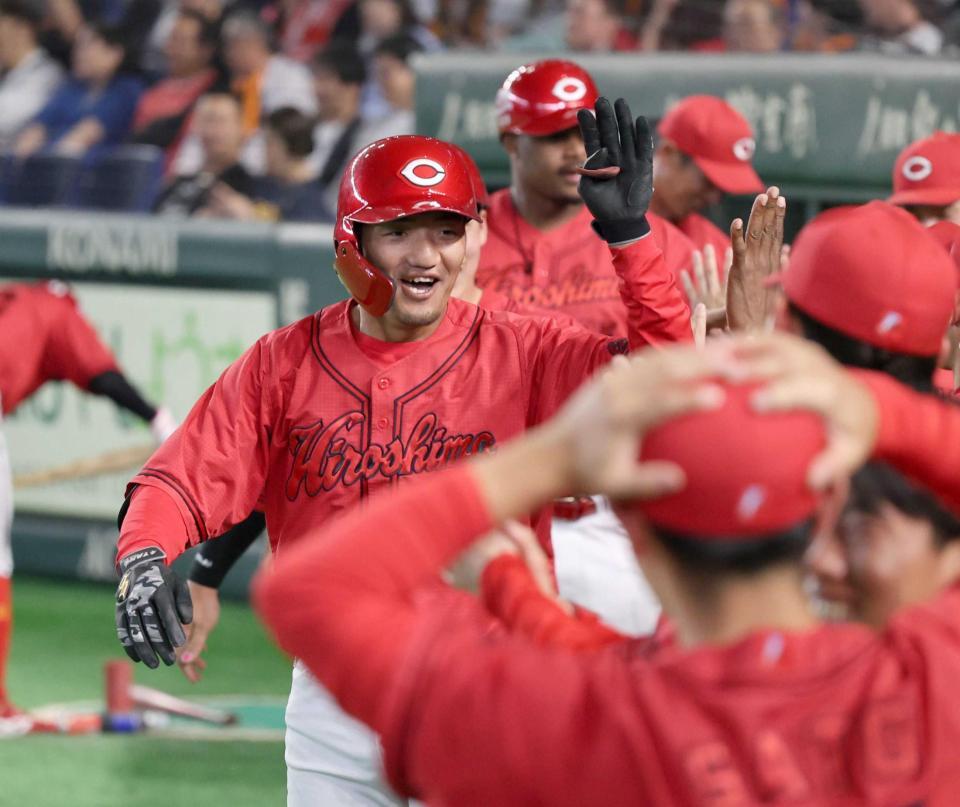 ９回、３ランを放ちベンチ前でナインに出迎えられる矢野（撮影・佐々木彰尚）