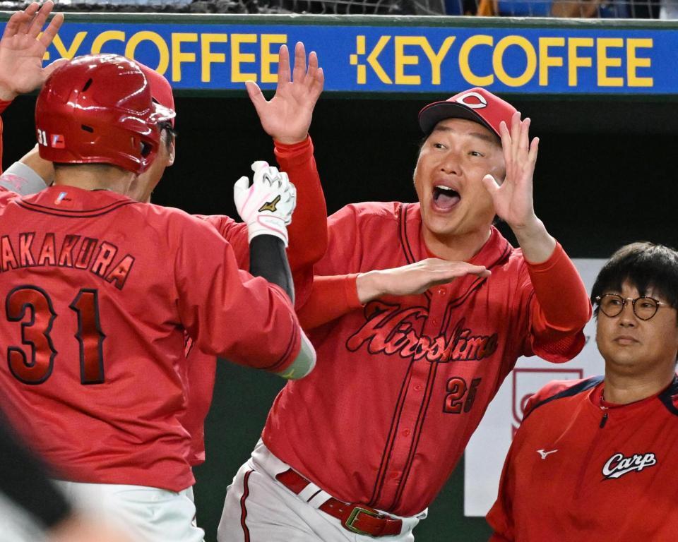 ８回、逆転３ランを放った坂倉（左）を迎える新井監督（中）