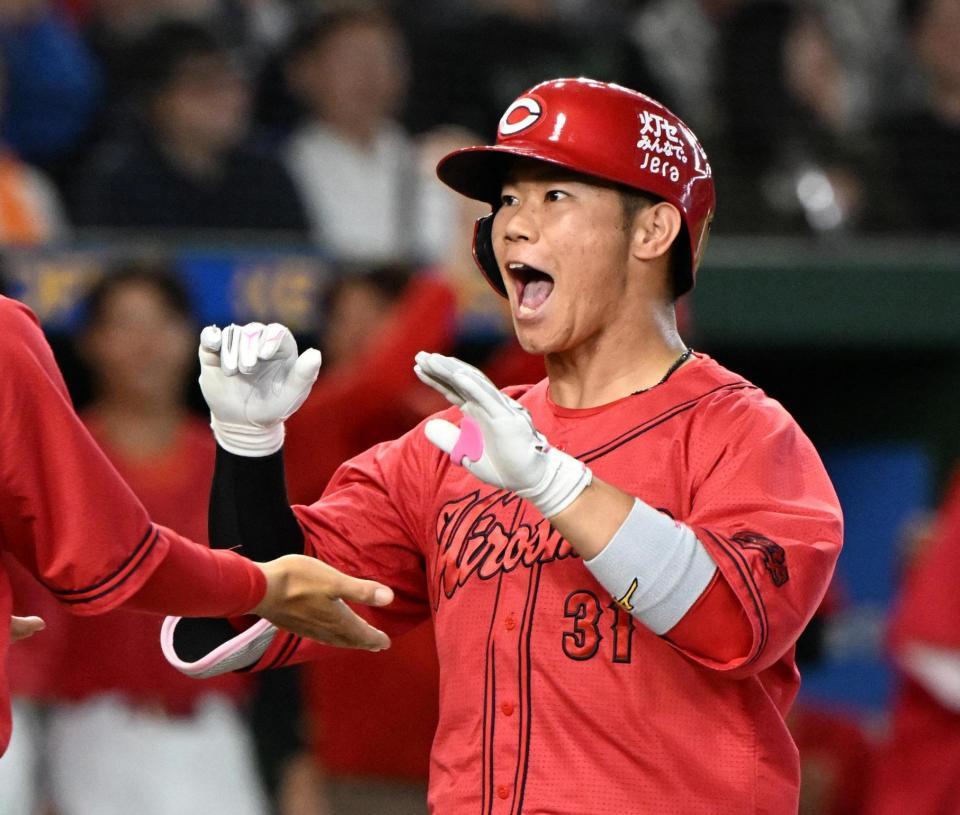 ８回、逆転３ランを放ち、コーチとタッチを交わす坂倉