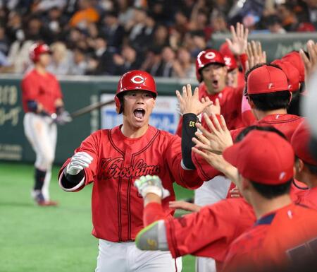 ８回、３ランを放ちベンチ前でナインに出迎えられる坂倉（撮影・佐々木彰尚）　