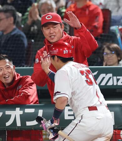 ７回裏、生還した野間（手前）を迎える新井監督