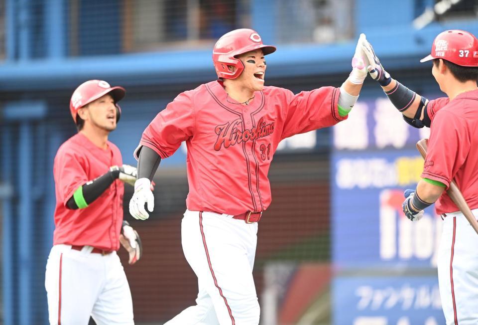 １回、先制満塁弾を放ちナインとハイタッチする坂倉（撮影・園田高夫）