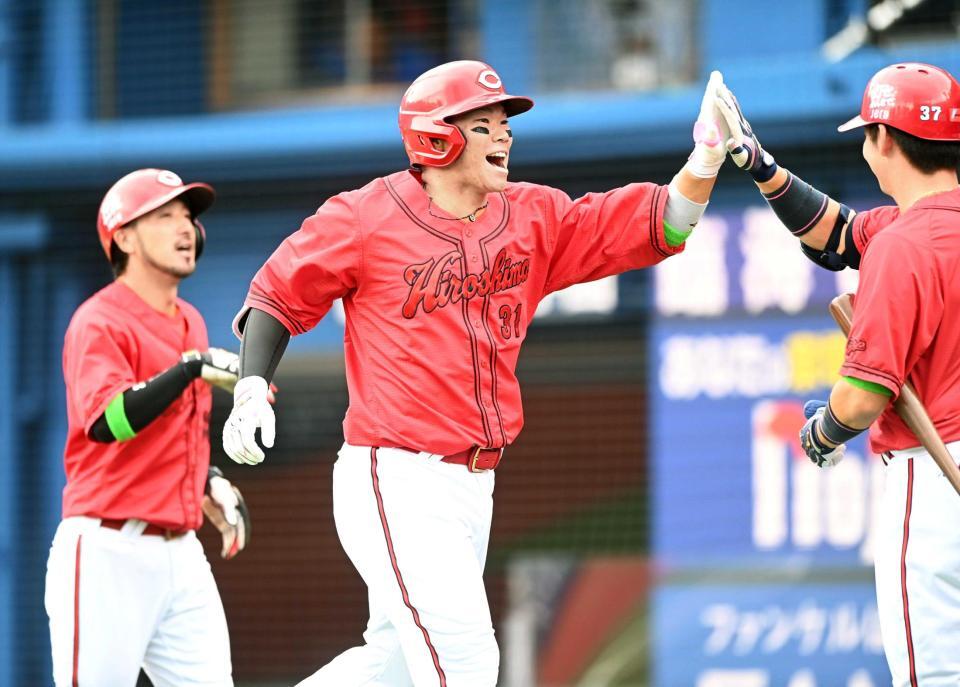 １回、先制満塁弾を放ちナインとタッチをする坂倉（撮影・園田高夫）