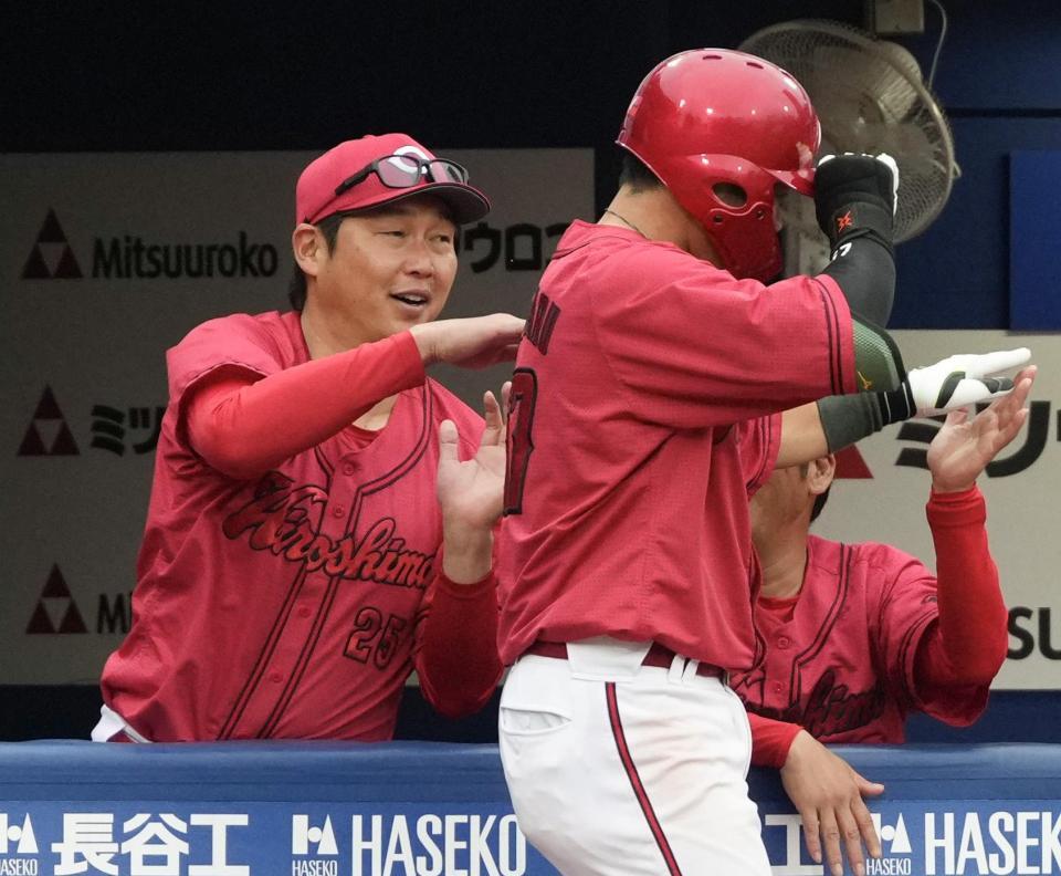 　６回、本塁打を放った持丸（右）を迎える新井監督