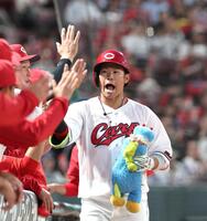 ４回、ソロを放った坂倉はナインとタッチを交わす（撮影・北村雅宏）